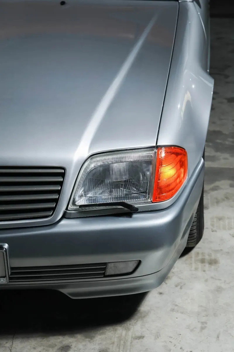 Close-up of a silver Mercedes-Benz headlight and front wing
